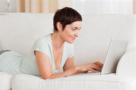 Happy short-haired woman using a laptop in her living room Stock Photo - Budget Royalty-Free & Subscription, Code: 400-04410642