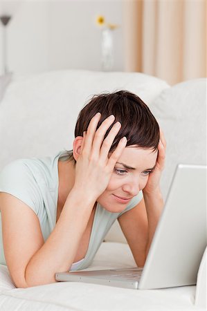 simsearch:400-05209351,k - Portrait of an unhappy woman using a laptop in her living room Stock Photo - Budget Royalty-Free & Subscription, Code: 400-04410656