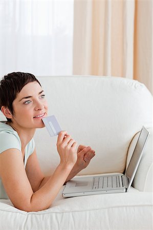 simsearch:400-05742016,k - Portrait of a pensive woman buying online in her living room Stock Photo - Budget Royalty-Free & Subscription, Code: 400-04410667