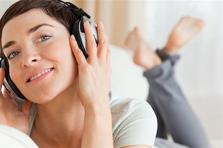 Close up of a smiling brunette listening to music lookig at the camera Stock Photo - Budget Royalty-Free & Subscription, Code: 400-04410727