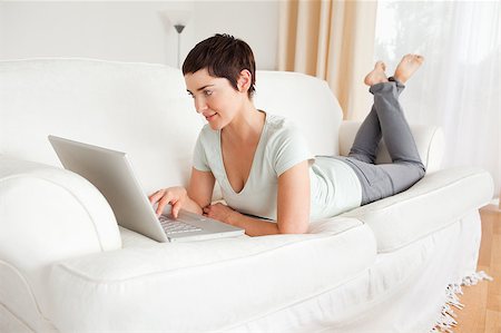 Happy short-haired woman using a laptop in her living room Stock Photo - Budget Royalty-Free & Subscription, Code: 400-04410742