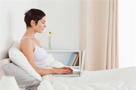 simsearch:400-04206266,k - Woman using a laptop in her bedroom Stockbilder - Microstock & Abonnement, Bildnummer: 400-04410768