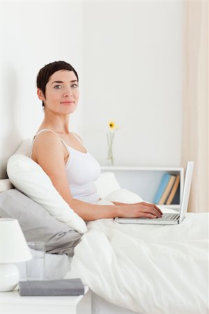 simsearch:400-04206266,k - Portrait of a cute woman using a laptop while looking at the camera Stockbilder - Microstock & Abonnement, Bildnummer: 400-04410792