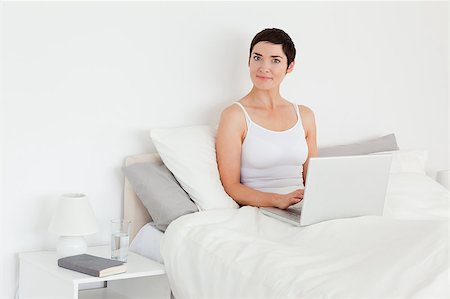 simsearch:400-04206266,k - Charming woman using a laptop in her bedroom Stockbilder - Microstock & Abonnement, Bildnummer: 400-04410834