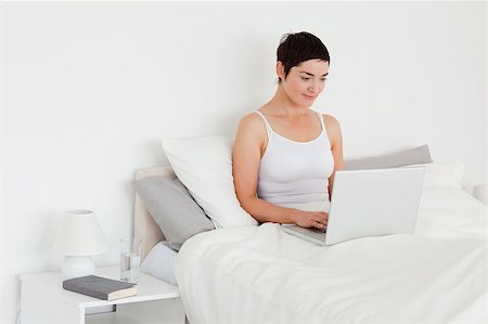 simsearch:400-04206266,k - Beautiful woman using a laptop in her bedroom Stockbilder - Microstock & Abonnement, Bildnummer: 400-04410847
