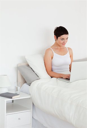 simsearch:400-04206266,k - Good looking woman using a laptop in her bedroom Stockbilder - Microstock & Abonnement, Bildnummer: 400-04410858