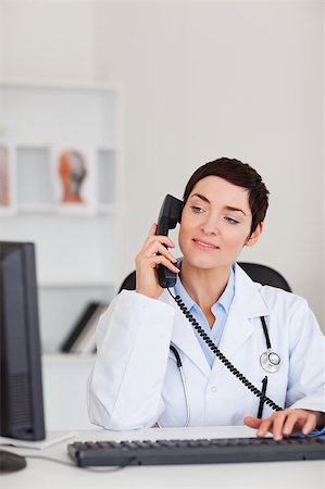 doctor business computer - Portrait of a female doctor making a phone call in her office Stock Photo - Budget Royalty-Free & Subscription, Code: 400-04410969