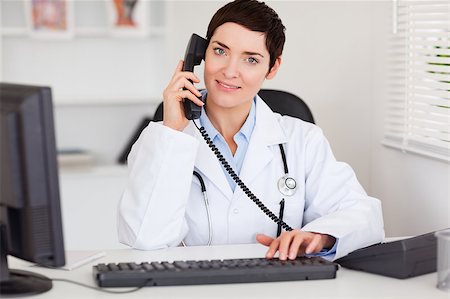 doctor business computer - Smiling female doctor making a phone call in her office Stock Photo - Budget Royalty-Free & Subscription, Code: 400-04410971
