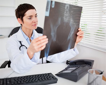 Young female doctor looking at X-ray in her living room Stock Photo - Budget Royalty-Free & Subscription, Code: 400-04411000