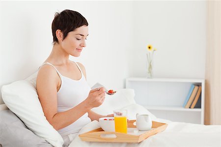 Brunette eating cereal in her bedroom Stock Photo - Budget Royalty-Free & Subscription, Code: 400-04411029