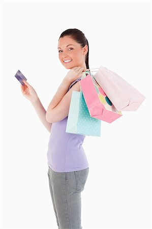 simsearch:400-05156727,k - Beautiful woman with a credit card holding shopping bags while standing against a white background Foto de stock - Super Valor sin royalties y Suscripción, Código: 400-04411095