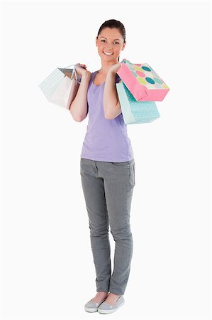 simsearch:400-05156727,k - Lovely woman holding shopping bags while standing against a white background Foto de stock - Super Valor sin royalties y Suscripción, Código: 400-04411101