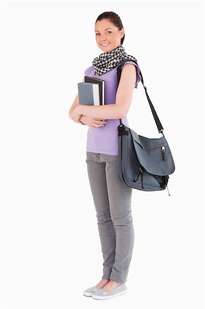 simsearch:400-05156727,k - Attractive student holding books and her bag while standing against a white background Foto de stock - Super Valor sin royalties y Suscripción, Código: 400-04411254