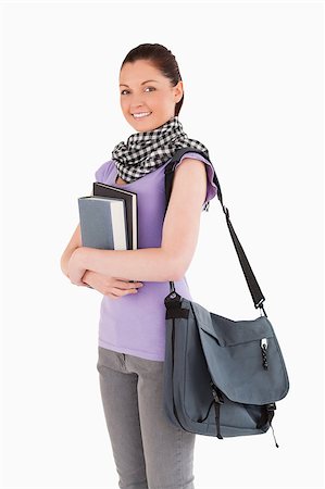 simsearch:400-04925223,k - Beautiful student holding books and her bag while standing against a white background Stock Photo - Budget Royalty-Free & Subscription, Code: 400-04411252