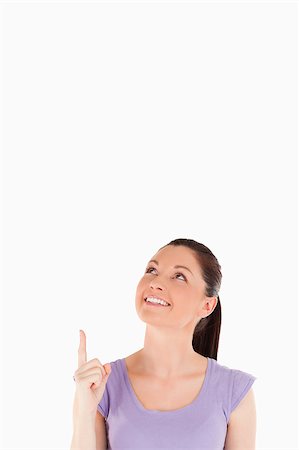 simsearch:400-04925223,k - Good looking female pointing at a copy space against a white background Stock Photo - Budget Royalty-Free & Subscription, Code: 400-04411290