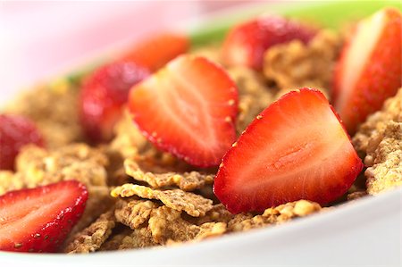 simsearch:400-04891088,k - Wholewheat flakes with fresh strawberry halves with a glass of strawberry yogurt in the back (Selective Focus, Focus on the strawberry half in the right bottom corner) Stock Photo - Budget Royalty-Free & Subscription, Code: 400-04411951