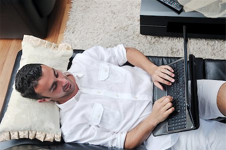 Portrait of a relaxed young guy using laptop at home indoor Stock Photo - Budget Royalty-Free & Subscription, Code: 400-04412244