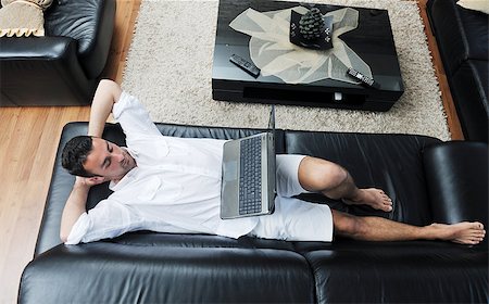 Portrait of a relaxed young guy using laptop at home indoor Foto de stock - Super Valor sin royalties y Suscripción, Código: 400-04412242