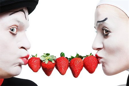 Couple of mimes taking the chain made of strawberries in the mouth and smiling on a white background Stock Photo - Budget Royalty-Free & Subscription, Code: 400-04413154