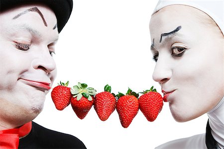 Couple of mimes taking the chain made of strawberries in the mouth and smiling on a white background Stock Photo - Budget Royalty-Free & Subscription, Code: 400-04413153