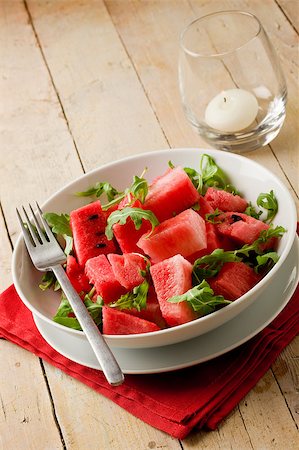 red water melon - photo of delicious fresh watermelon and arugula salad on wooden table Photographie de stock - Aubaine LD & Abonnement, Code: 400-04413284
