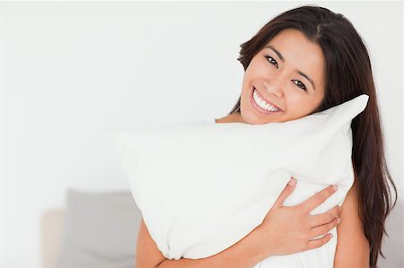 close up of a charming woman with pillow sitting on her bed looking into camera in bedroom Stock Photo - Budget Royalty-Free & Subscription, Code: 400-04413718