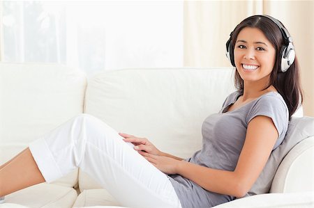 simsearch:6109-06194965,k - woman with earphones sitting on sofa in livingroom Foto de stock - Super Valor sin royalties y Suscripción, Código: 400-04413921