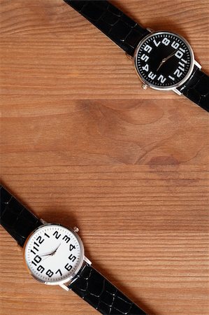 Pair of modern black and white wristwatches on wooden surface Foto de stock - Super Valor sin royalties y Suscripción, Código: 400-04424004