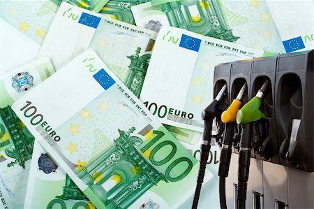 simsearch:400-04307179,k - Three gas pump nozzles over a money background Fotografie stock - Microstock e Abbonamento, Codice: 400-04425447