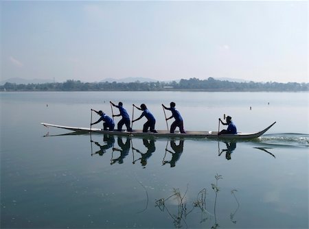 Four paddlers and a helmsman practicing early in the morning onboard a small dragonboat near Pattaya, Chonburi province in Thailand. Photographie de stock - Aubaine LD & Abonnement, Code: 400-04426336