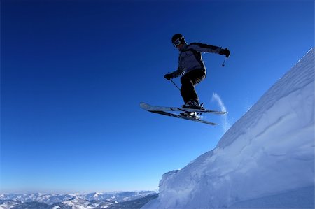 simsearch:400-03986055,k - Skier flying off a cornice with mountains in the background Photographie de stock - Aubaine LD & Abonnement, Code: 400-04427476