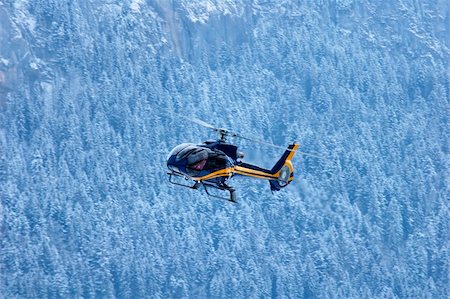 simsearch:400-05128461,k - A mountain rescue helicopter coming in to land against a backdrop of snowy mountain forest. Stockbilder - Microstock & Abonnement, Bildnummer: 400-04427645