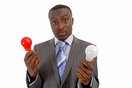 This is an image of a businessman trying to decide the best idea, represented by the light bulbs. The red buld can also be used to represent bad idea and the white bulb good idea. Fotografie stock - Microstock e Abbonamento, Codice: 400-04428579