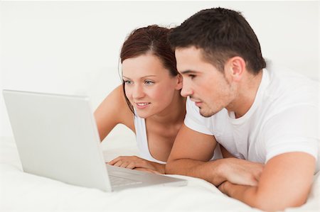 simsearch:400-04182849,k - Cheerful couple with a laptop in the bedroom Stock Photo - Budget Royalty-Free & Subscription, Code: 400-04420858