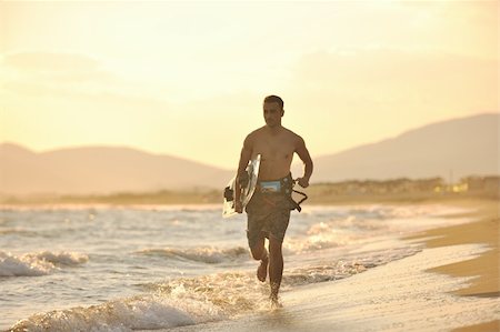 surfers men model - Portrait of a strong young  surf  man at beach on sunset in a contemplative mood with a surfboard Stock Photo - Budget Royalty-Free & Subscription, Code: 400-04423812