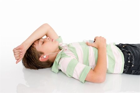 simsearch:400-04434331,k - A young boy lying down listening to music on a digital portable mp3 player. Photographie de stock - Aubaine LD & Abonnement, Code: 400-04435115