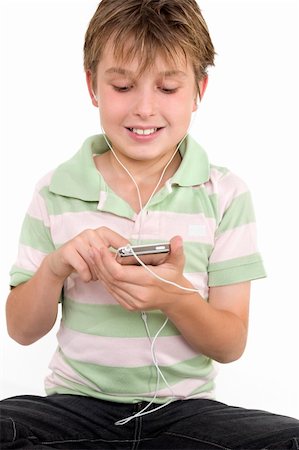 simsearch:400-04434331,k - Child sitting down using a digital player.  He is wearing a striped polo shirt and jeans. Photographie de stock - Aubaine LD & Abonnement, Code: 400-04435203