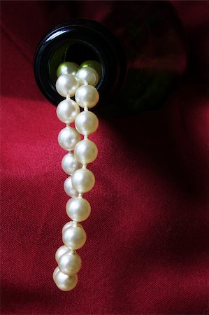 Luxury concept with pearls flowing out of a champagne bottle against a red drape Stock Photo - Budget Royalty-Free & Subscription, Code: 400-04435965