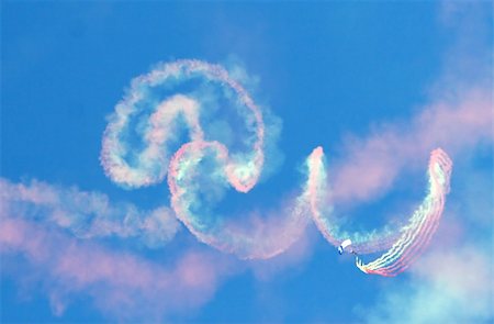 person falling in the wind - A parachute jumper with smoke canisters leaves a colorful trail in the blue sky Stock Photo - Budget Royalty-Free & Subscription, Code: 400-04436125