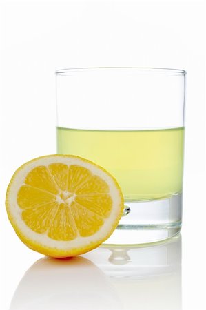 simsearch:400-03950882,k - A half and glass of fresh lemon juice reflected on white background Stockbilder - Microstock & Abonnement, Bildnummer: 400-04436485