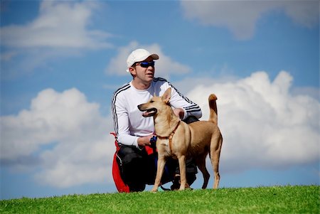 athletic man relaxing outdoors with his dog Stock Photo - Budget Royalty-Free & Subscription, Code: 400-04437247