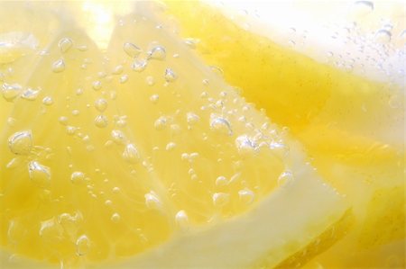 Lemon slices covered in air bubbles from the sparkling water Foto de stock - Super Valor sin royalties y Suscripción, Código: 400-04437261