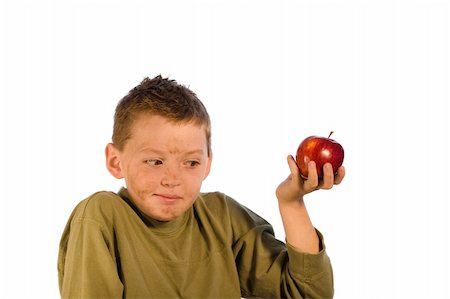simsearch:400-04979626,k - Very dirty young boy holding an apple and looking embarrased. Studio shot isolated on a white background. Foto de stock - Super Valor sin royalties y Suscripción, Código: 400-04437405
