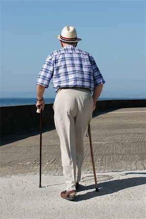 rheumatoid arthritis - Rear view of an elderly man walking with walking sticks on a beach promenade. Stock Photo - Budget Royalty-Free & Subscription, Code: 400-04438030