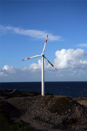 wind turbine near the sea under a blue sky and clouds Foto de stock - Super Valor sin royalties y Suscripción, Código: 400-04438057