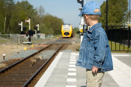 Little boy waiting for the train to come on a railway station. Stock Photo - Budget Royalty-Free & Subscription, Code: 400-04438603