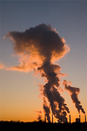 simsearch:400-04430626,k - Silhouette of smoke stacks smoking into the sky at sunset Photographie de stock - Aubaine LD & Abonnement, Code: 400-04430626