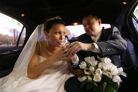 simsearch:400-04440941,k - The bride with the groom drinks champagne in the automobile Fotografie stock - Microstock e Abbonamento, Codice: 400-04431760