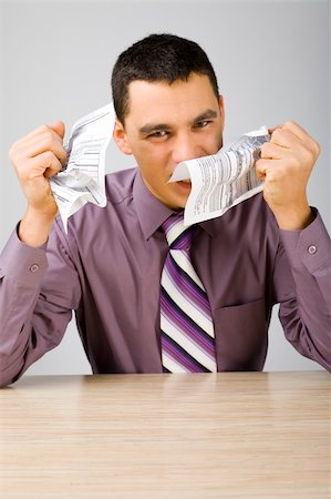 Angry man at the desk crumpling two sheets of paper. (paper's form is copyright free) Stock Photo - Budget Royalty-Free & Subscription, Code: 400-04432002