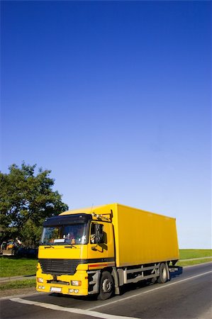 simsearch:400-06069419,k - Yellow truck on asphalt road. Large blue sky with place for copy text. Stock Photo - Budget Royalty-Free & Subscription, Code: 400-04433312